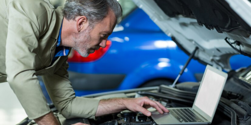 mechanic-using-laptop-while-servicing-car-engine_1170-1304